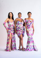 Three bridesmaids in pink and purple floral print dresses, including the Livvy draped mini