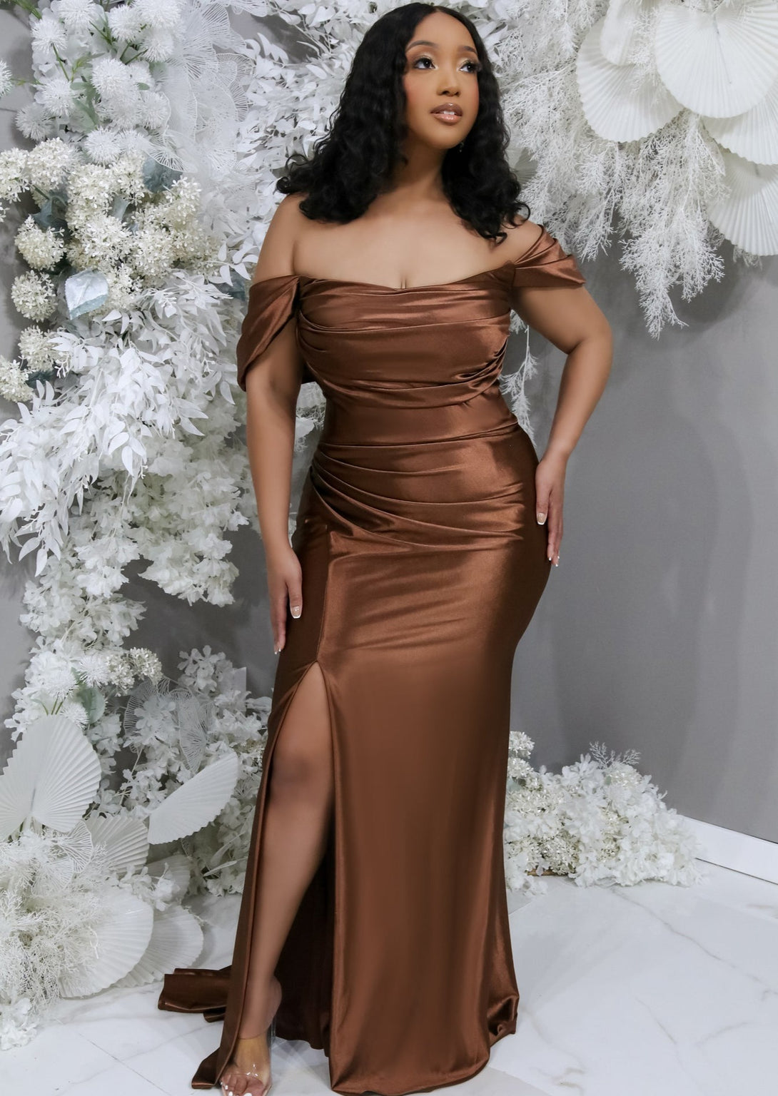 Fitted chocolate stretch satin bridesmaid dress with off-the-shoulder detailing, ruching, and slit on plus-size model