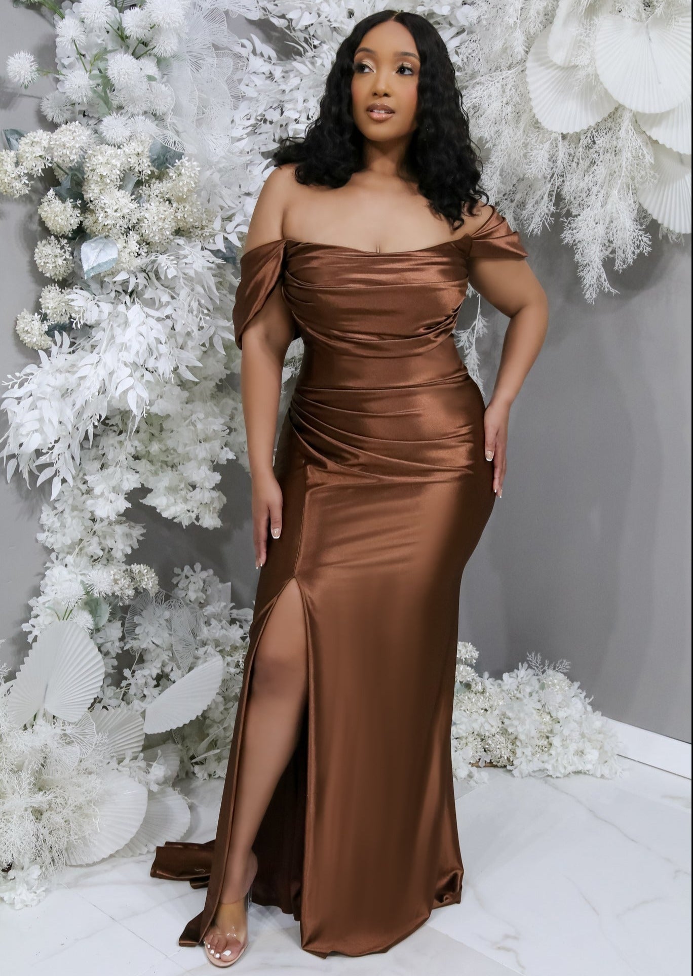 Fitted chocolate stretch satin bridesmaid dress with off-the-shoulder detailing, ruching, and slit on plus-size model