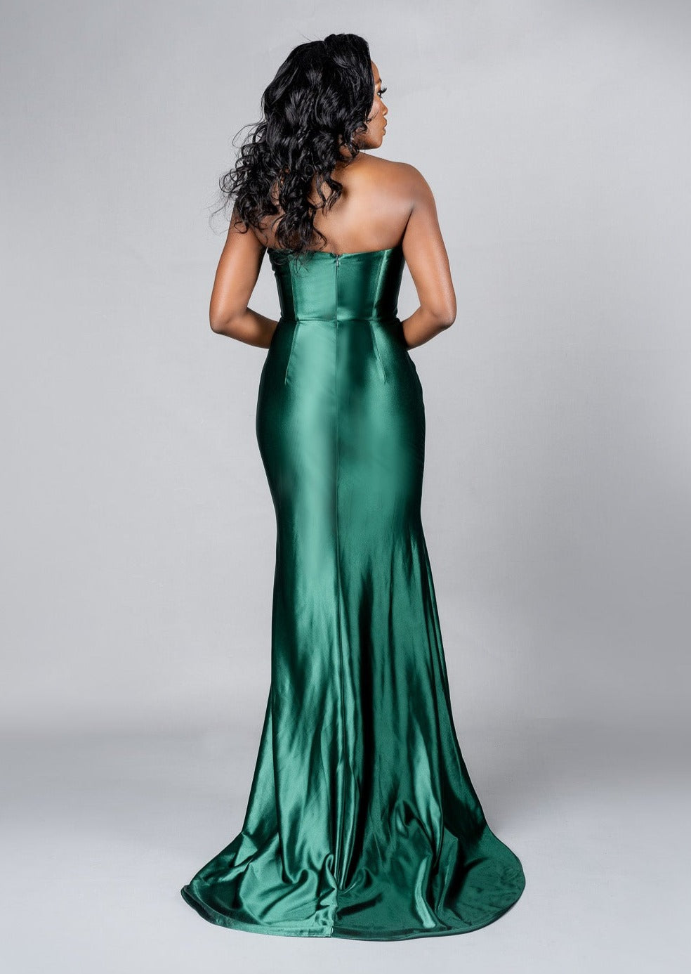 Super sexy bridesmaid dress in stretch satin with a slit, twisted detailing with ruching at the hip. Shown on a curvy black model - back view