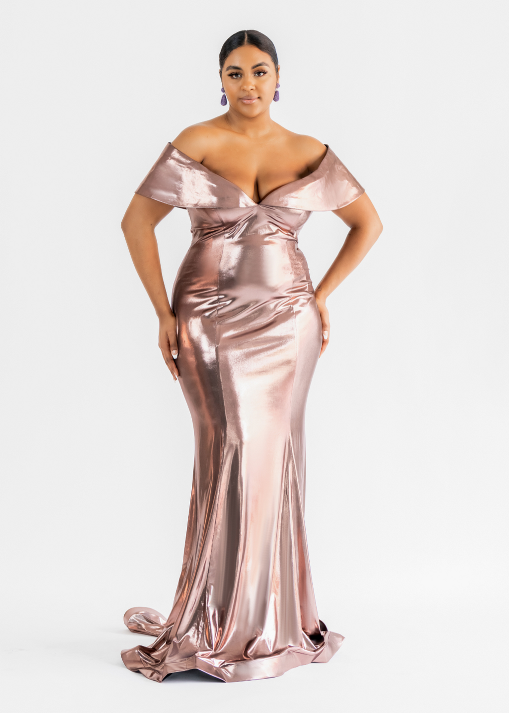 Virgo rose gold metallic gown with an off-the-shoulder neckline, ruched body and mermaid train, shown on a curvy model