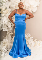 Plus size bridesmaid wearing a beautiful blue mermaid stretch satin bridesmaid dress with spaghetti straps, sweetheart neckline, and belt that cinches the waist and shows off the hips with stretch throughout the dress. Shown on black mid size model