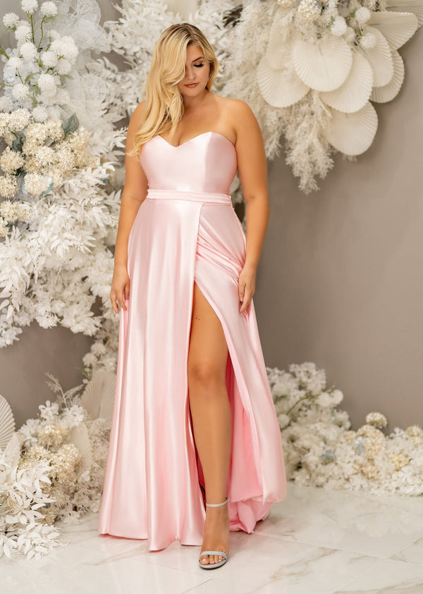 Light pink flowy A-Line bridesmaid dress with sweetheart neckline bridesmaid dress with belted waist and skirt slit on plus-size model