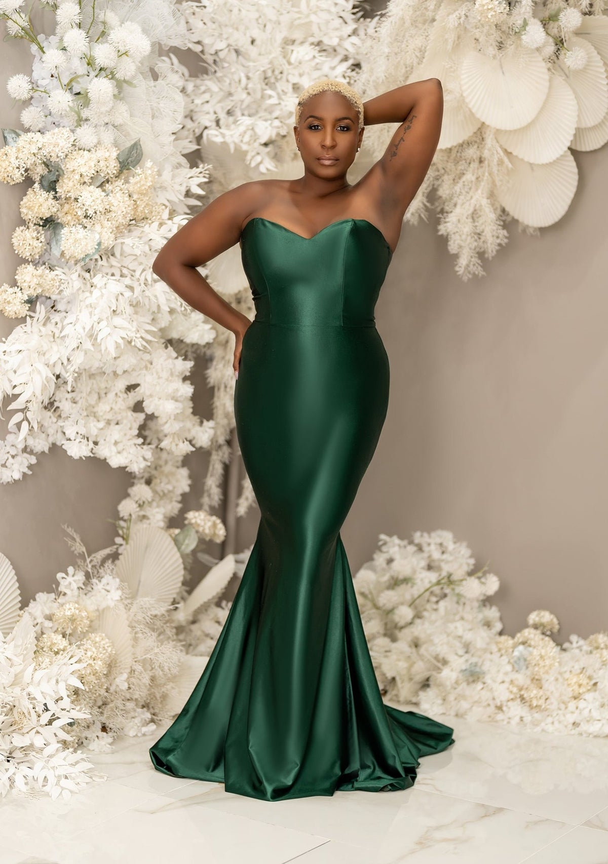 Plus size black bridesmaid wearing a sexy strapless emerald green mermaid bridesmaid dress with stretch to flaunt curves