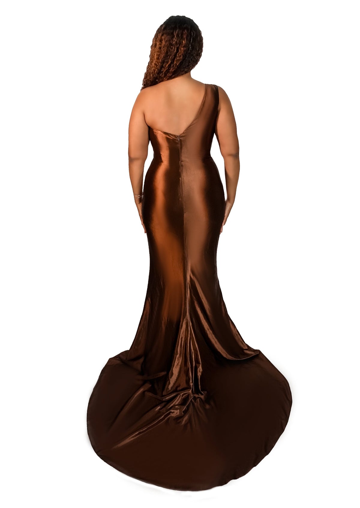 Plus size bridesmaid in asymmetrical fit and flare stretch satin bridesmaid dress with pleated bodice and hugs the hips. Shown in a deep chocolate on a plus size black model. - back view
