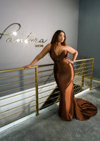 Plus size bridesmaid in asymmetrical fit and flare stretch satin bridesmaid dress with pleated bodice and hugs the hips. Shown in a deep chocolate on a plus size black model.
