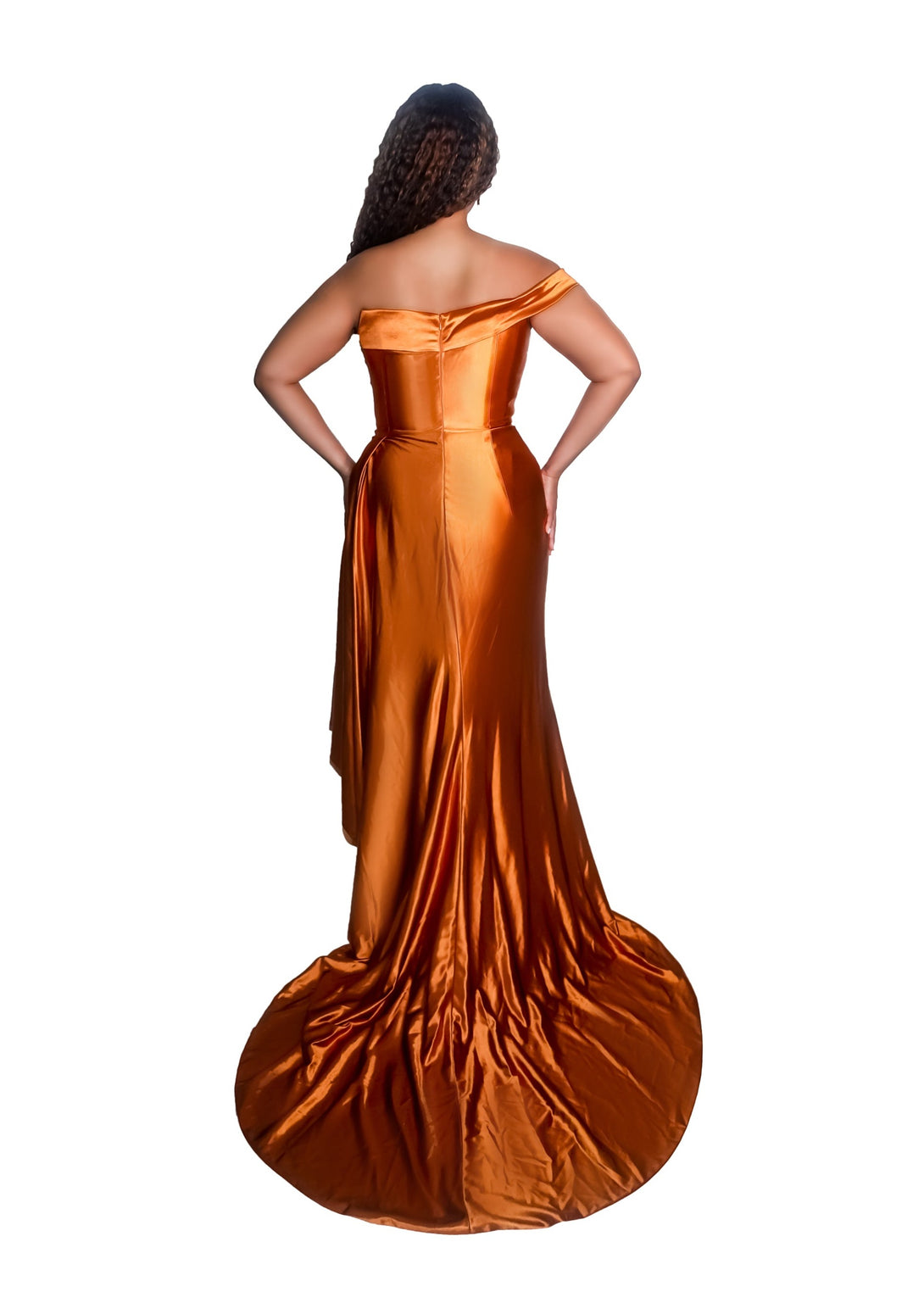 Plus size bridesmaid in asymmetrical fitted stretch satin bridesmaid dress with ruching at the waist and through the skirt and an off-the-shoulder strap. This style is designed to flatter and complement all body types. Shown in burnt orange on a curvy black model. - back view