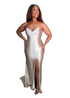 Curvy mid size bridesmaid wearing a strapless fitted bridesmaids dress with stretch. This classic sexy dress has a slit at the leg and is shown on a black model.